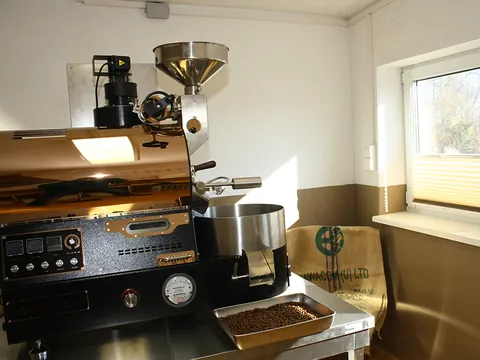 Kaffeeröster mit frisch gerösteten Bohnen im Auffangblech